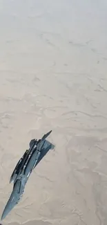 Jet flying over a beige desert landscape, capturing aerial aviation beauty.