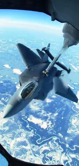 Aerial view of a jet being refueled in-flight against a clear blue sky.