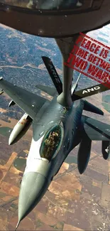 Fighter jet in mid-air refueling with farmland below.