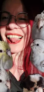 Woman smiling with colorful birds and a small puppy on a vibrant wallpaper.