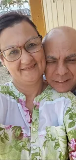 Happy couple embracing outdoors with flowers and soft lighting.