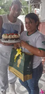 Two people happily celebrating with a cake and gift bag.