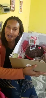 A happy woman holding a cake gift box in joy.