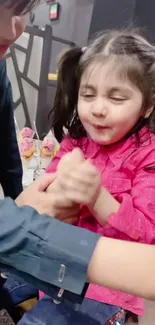 A cheerful child enjoying a playful moment in vibrant pink attire.