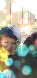 A child smiling with colorful bokeh light overlay on mobile wallpaper.