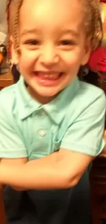 Joyful child in blue shirt with a big smile.