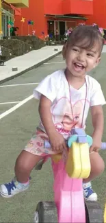 Joyful child riding a toy bike with vibrant colors and a smile.