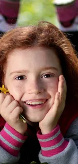 Joyful child holding flowers with a bright smile and lush greenery.