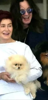 Joyful couple holding adorable Pomeranians, smiling warmly.