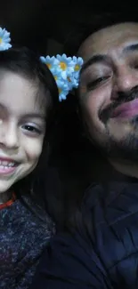 Father and daughter smiling with flower crowns.