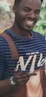 Smiling man in striped shirt with floral background.