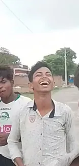 Group of friends laughing outdoors on a cloudy day.