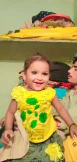 Smiling child in a bright yellow outfit.