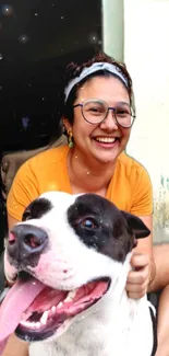 Woman smiling with her cheerful dog close by in a bright, vibrant setting.