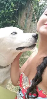 Woman smiling with a loving white husky outdoors.