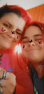 Mother and daughter smiling with butterfly stickers on faces.