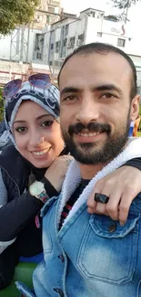 Smiling couple enjoying an outdoor moment in casual attire.