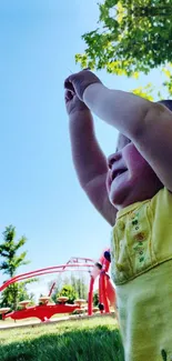 Child playing joyfully under a sunny sky at the park.