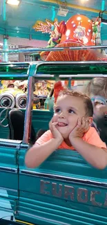 Boy enjoys a colorful ride at the funfair with vibrant teal surroundings.