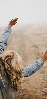 Person enjoying freedom on a road trip with open arms through car window.