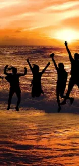 Silhouetted friends jumping at sunset on a beach with vibrant orange sky.