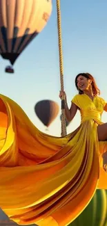 Woman in yellow dress swinging joyfully with hot air balloons in the background.