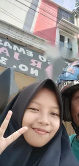 Urban selfie with peace sign and smiles in city backdrop.