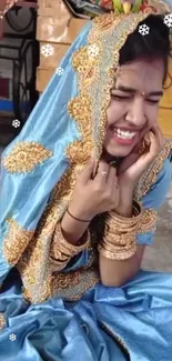 Smiling woman in blue traditional clothing with gold details.