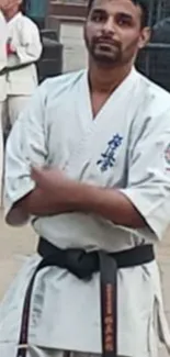 Karate practitioner posing outdoors in traditional white gi.