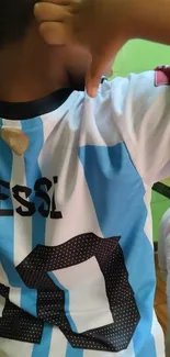 Child in striped soccer jersey showing excitement.