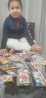 Child sitting amidst colorful candies on a table.