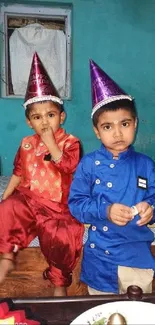 Two kids enjoying a vibrant birthday party with festive hats.