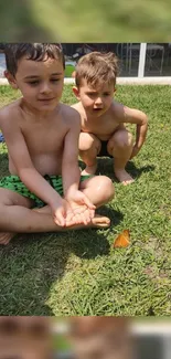 Two children playing on green grass outside in summer.