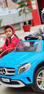 Kids in toy cars enjoying playful outdoor fun.