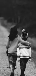 Two kids walking down a forest path in black and white.