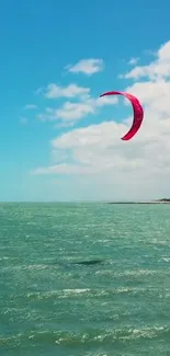 Kite surfing over turquoise ocean under a clear blue sky.