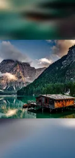 Breathtaking lakeside view with mountains and cabin.