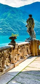 Lakeside view with mountains and stone sculpture on a terrace.