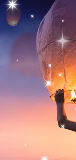 Boy releasing sky lantern at sunset with glowing backdrop.