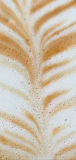 Close-up of latte art with coffee foam swirls in light brown and creamy textures.