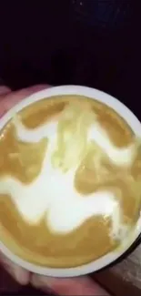 Latte art with intricate swirl design in a coffee cup.