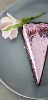 Lavender cake slice on a grey plate with pink flower.