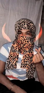 Person with leopard print scarf and red horns on a mobile wallpaper.