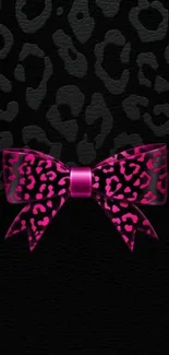 Leopard print with pink bow on black background wallpaper.