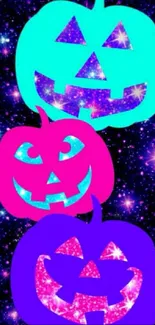 Three colorful pumpkin faces on a galaxy background.