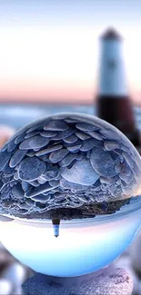 Lighthouse reflection in a crystal sphere against a tranquil blue seascape.