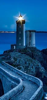 Lighthouse on rocky coast at dusk with starry glow.