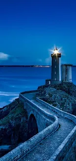 Lighthouse by the sea at dusk with a blue sky and ocean waves.