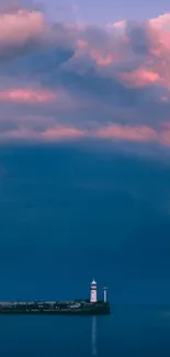Lighthouse with dramatic sunset sky and pink clouds over the ocean.