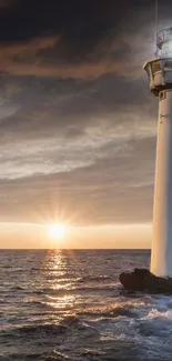 Lighthouse silhouetted against a vibrant sunset over the ocean.